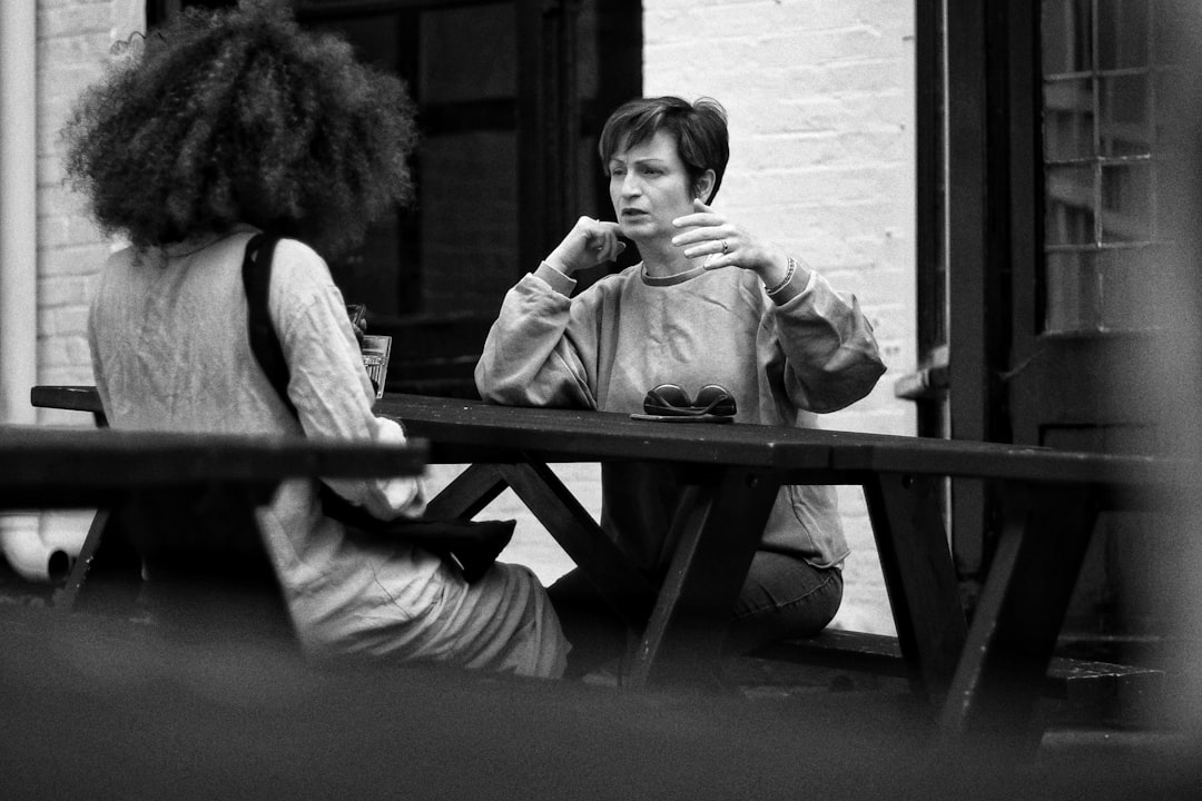 Reading, Berkshire: grayscale photo of two women sitting on bench